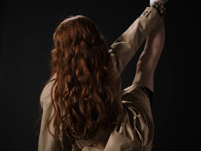 Woman performing a mindful stretching movement in soft lighting.
